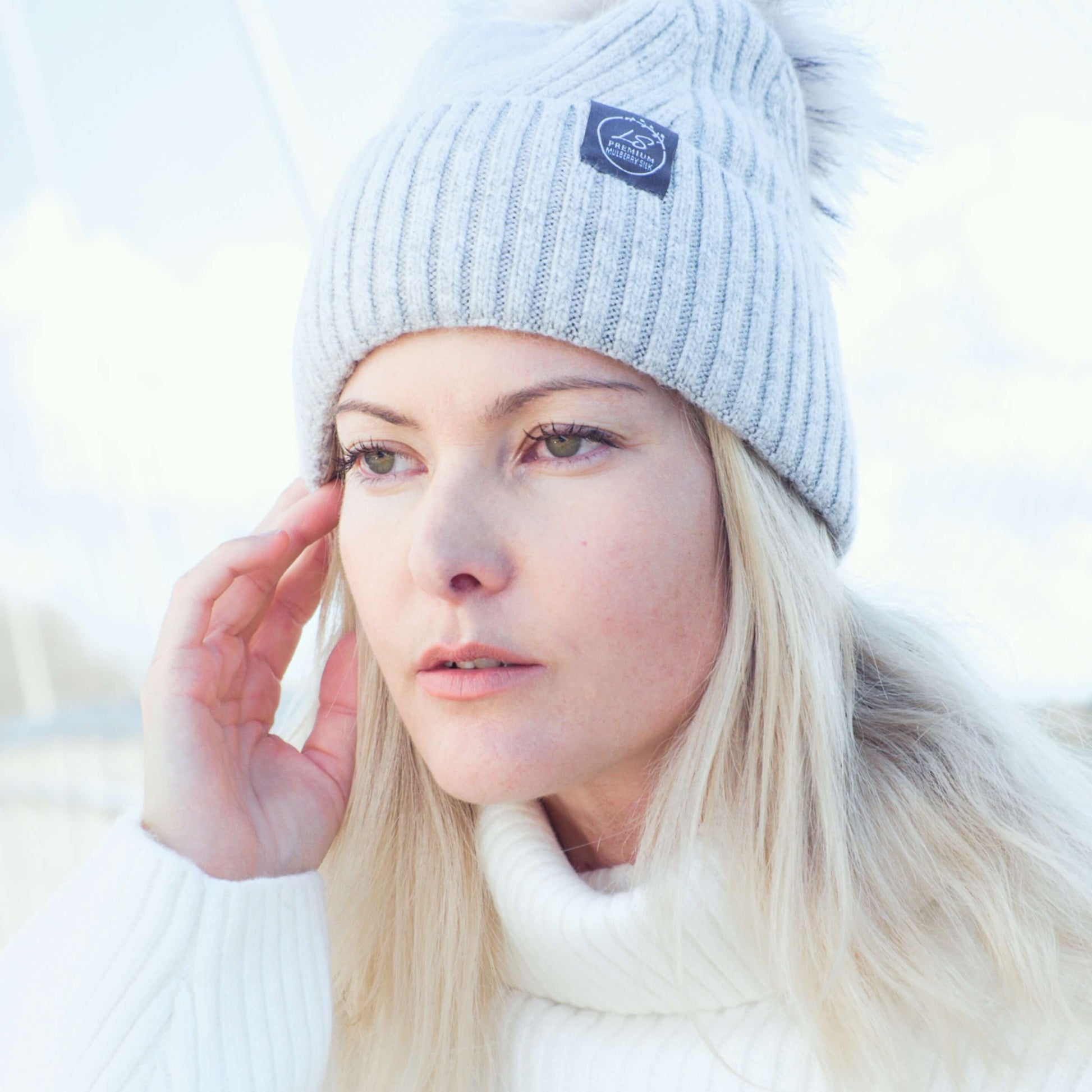 Woman outdoors wearing light grey silk-lined pom pom beanie – LS Silk NZ