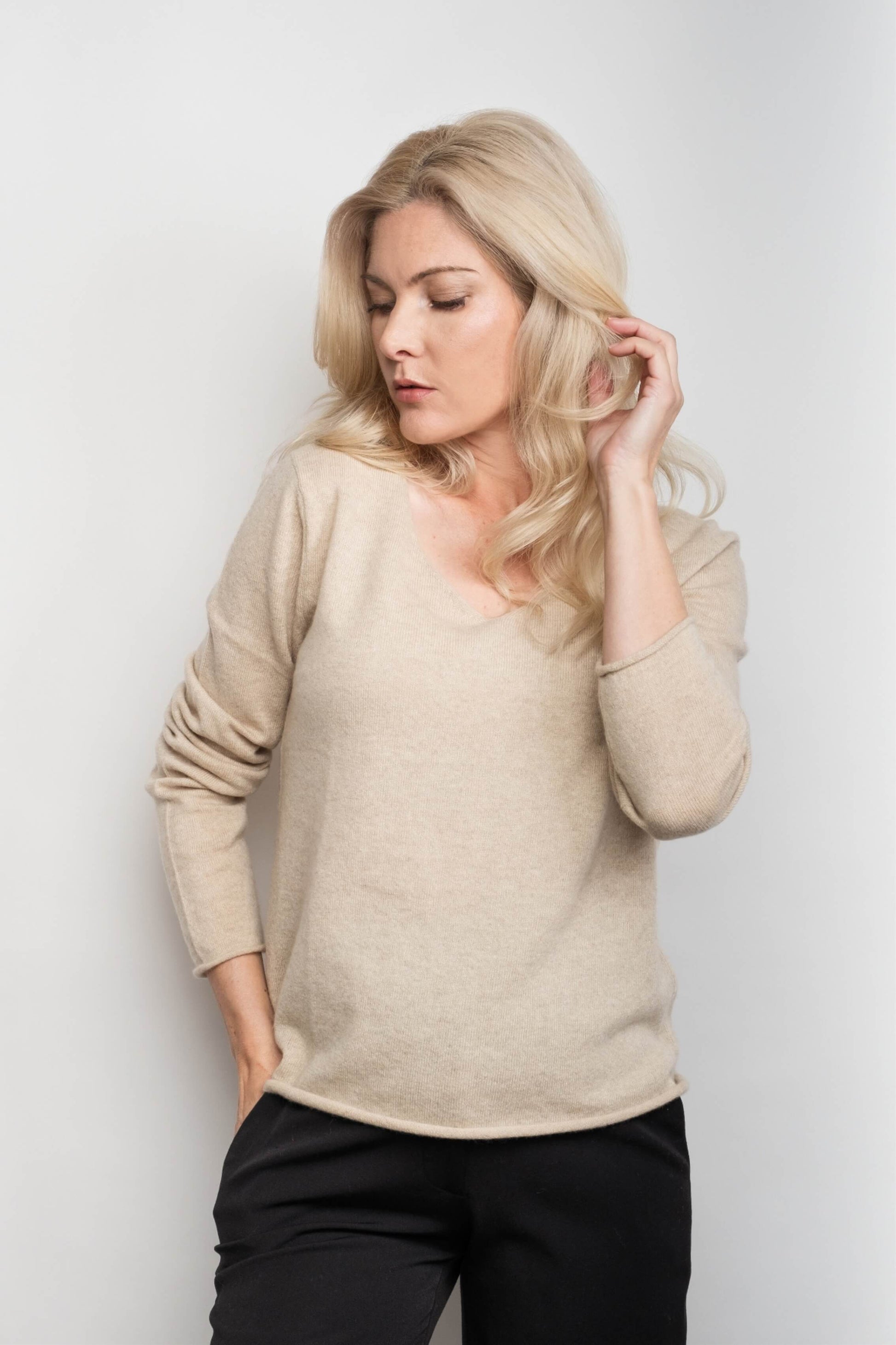 Woman in beige relaxed V-neck pure cashmere sweater – Love Cashmere NZ