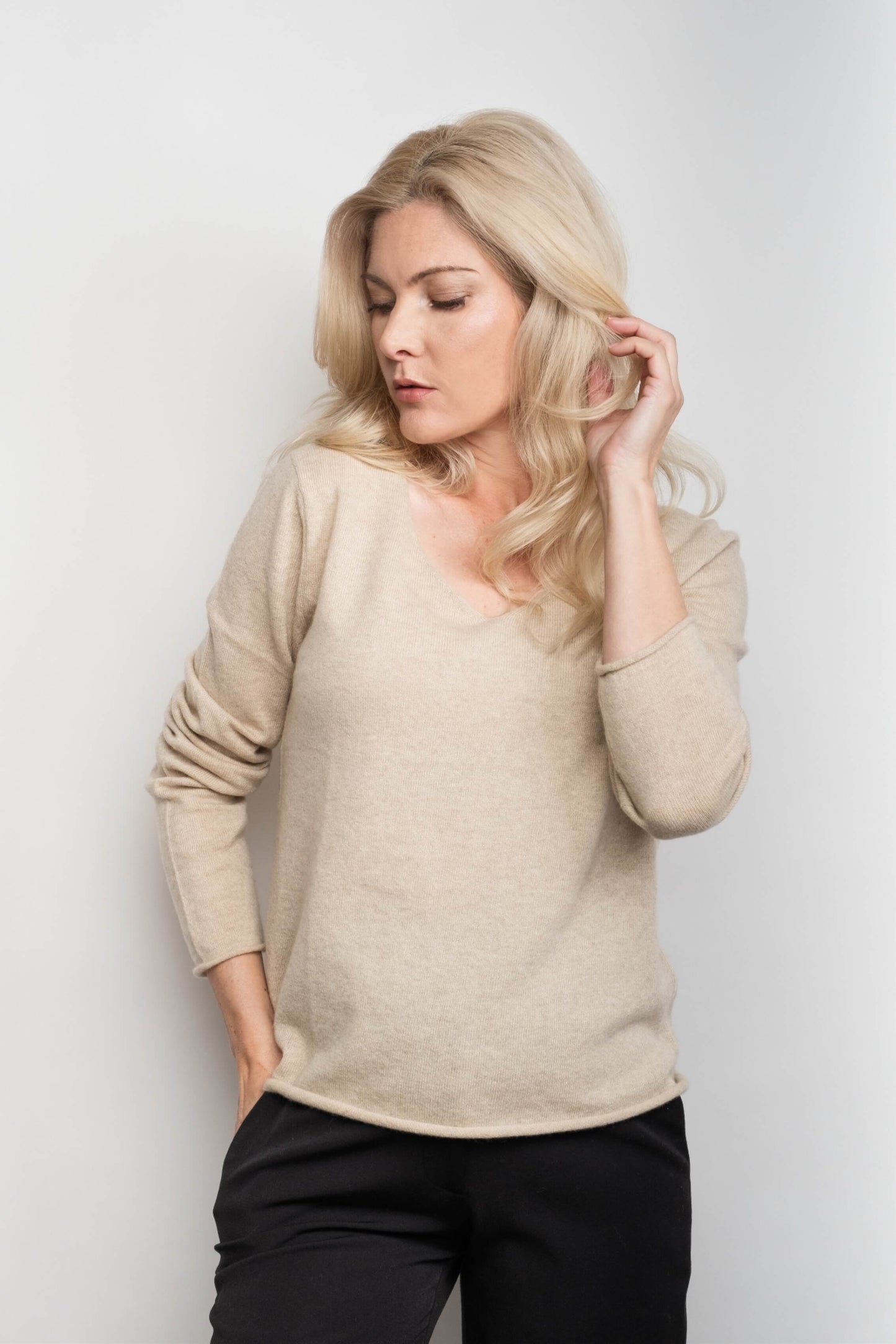 Woman in beige relaxed V-neck pure cashmere sweater – Love Cashmere NZ