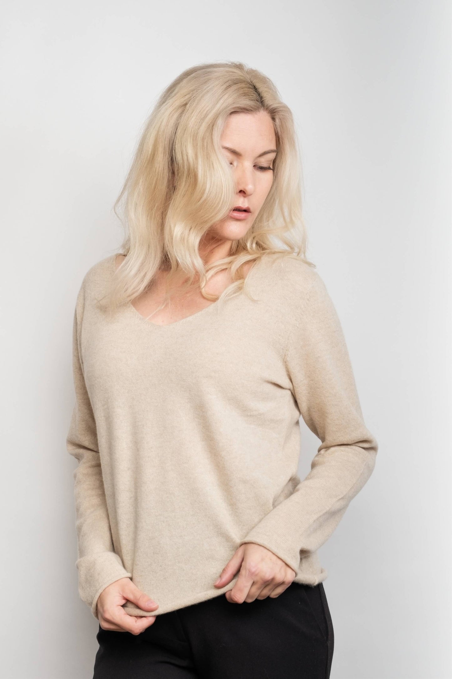 Model in loose-fit beige V-neck cashmere sweater, front view – Love Cashmere NZ