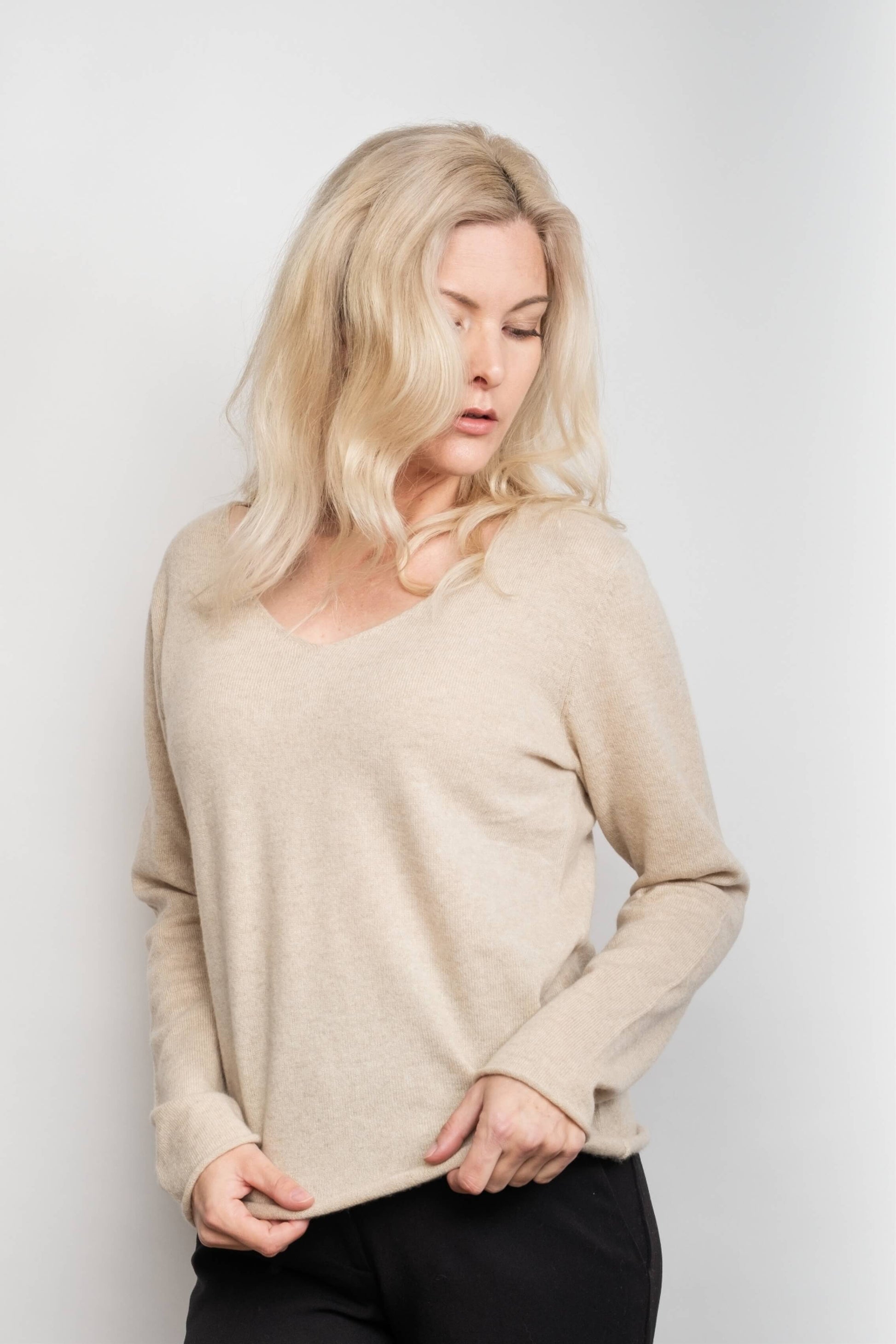Model in loose-fit beige V-neck cashmere sweater, front view – Love Cashmere NZ