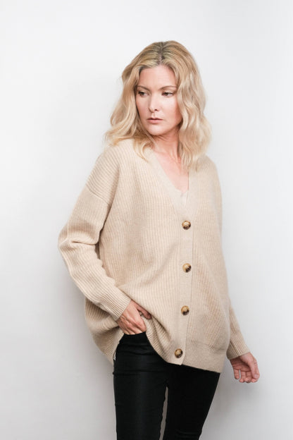 Model wearing buttoned beige cashmere cardigan, studio view – Love Cashmere NZ