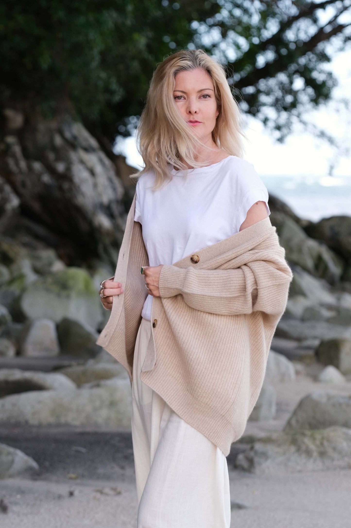 Model with beige cashmere cardigan draped over shoulders at beach – Love Cashmere NZ