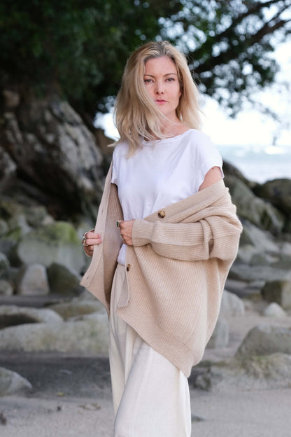 Model with beige cashmere cardigan draped over shoulders at beach – Love Cashmere NZ