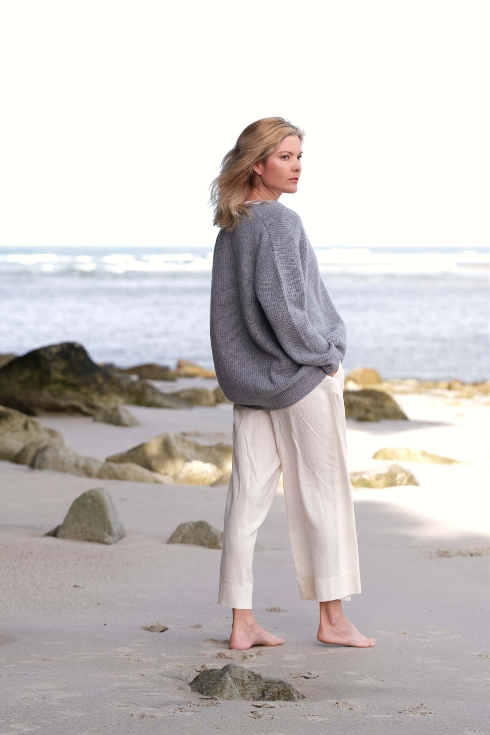 Woman in grey cashmere cardigan looking out to sea – Love Cashmere NZ