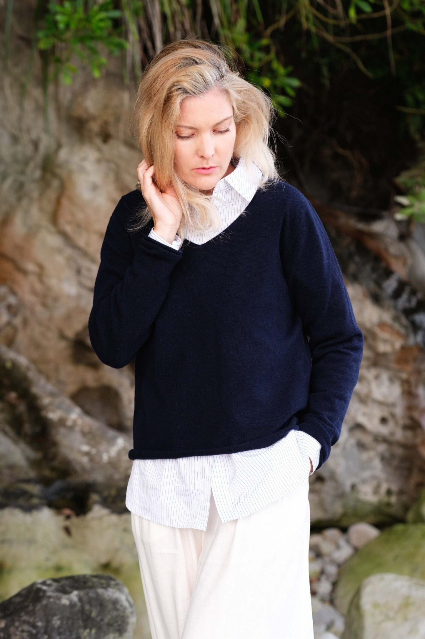 Woman in navy cashmere sweater and white shirt outdoors – Love Cashmere NZ