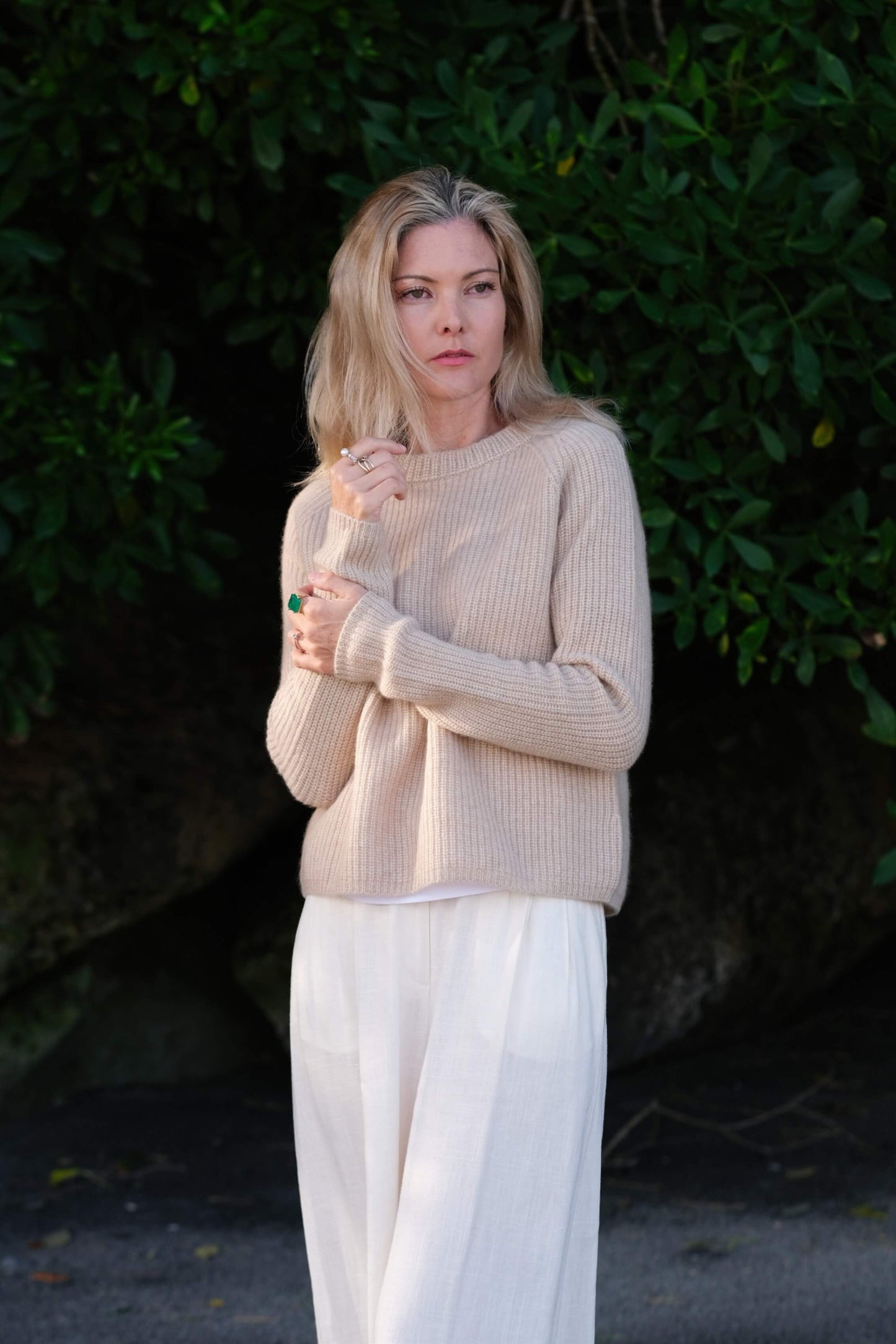 Woman in beige fisherman cashmere sweater holding collar outdoors – Love Cashmere NZ