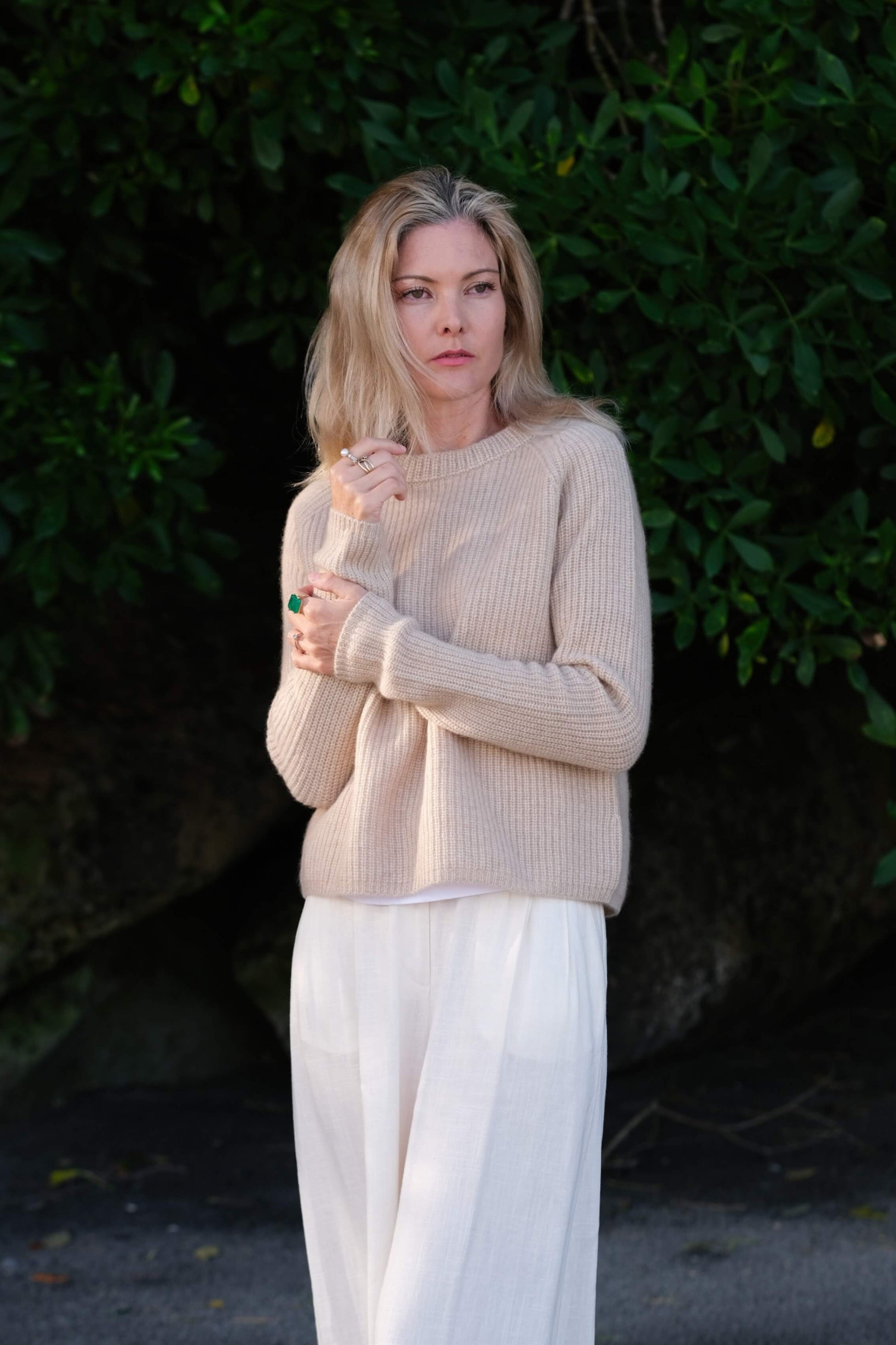 Woman in beige fisherman cashmere sweater holding collar outdoors – Love Cashmere NZ