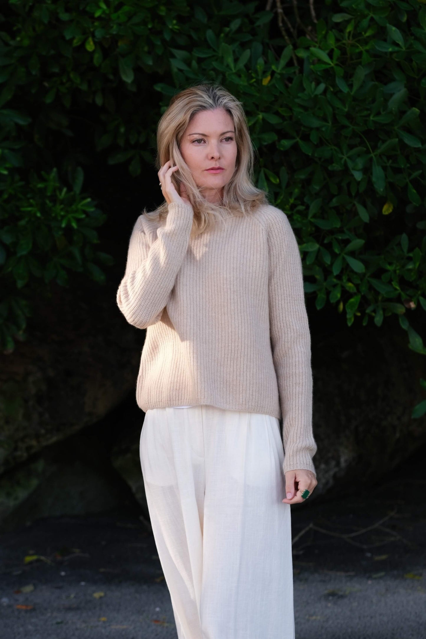 Model in beige cashmere fisherman sweater against greenery – Love Cashmere NZ