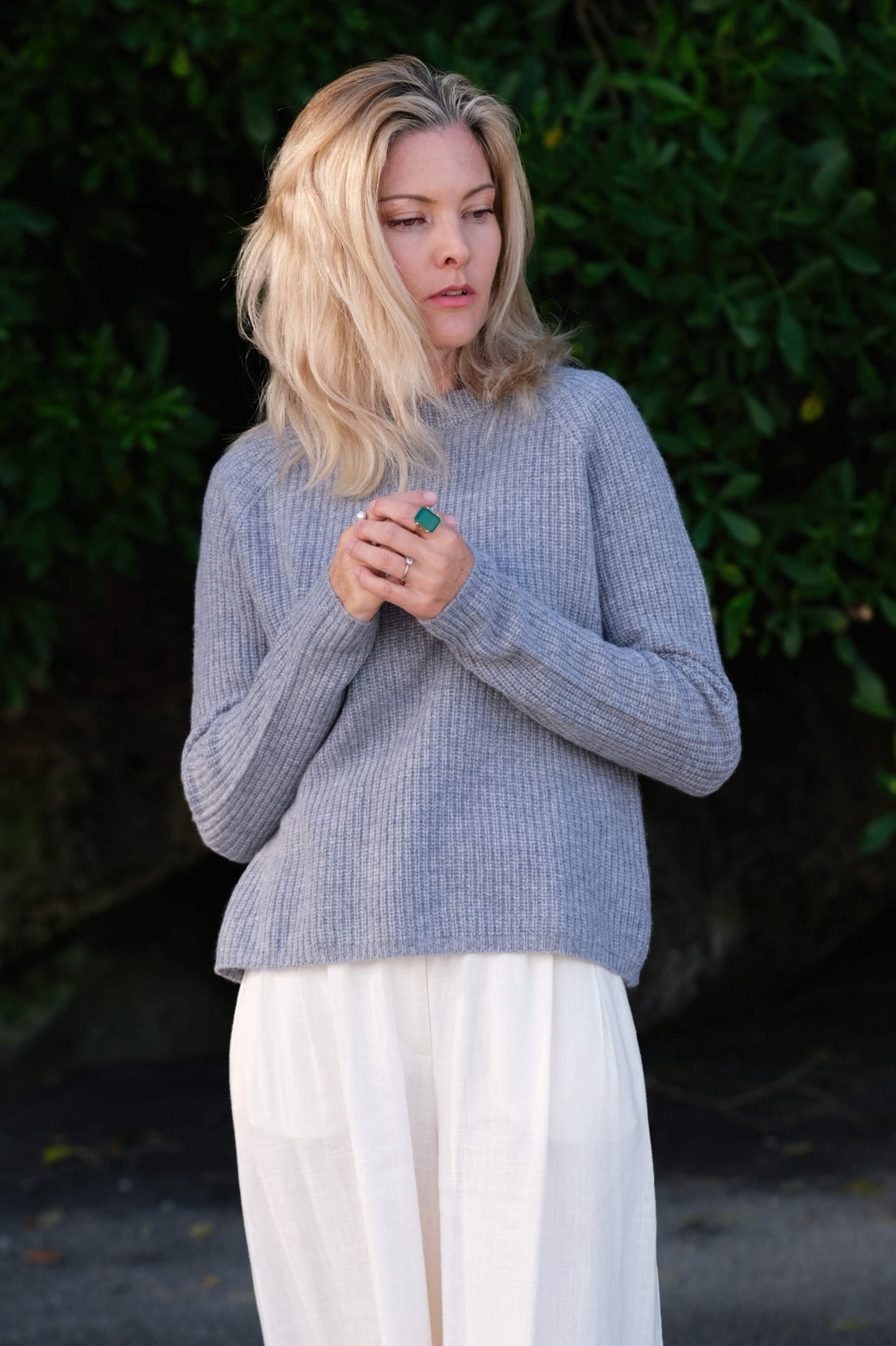 Model in grey cashmere fisherman sweater, hands clasped outdoors – Love Cashmere NZ