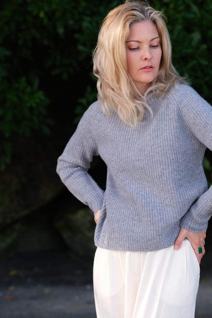 Woman outdoors in grey fisherman cashmere sweater, hand on hip – Love Cashmere NZ