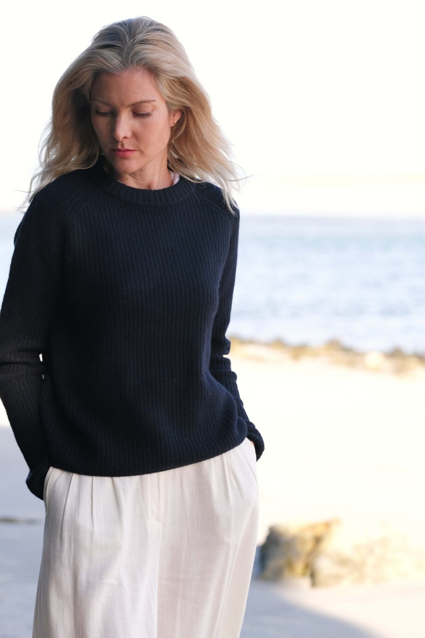 Model in black fisherman cashmere sweater in beach light – Love Cashmere NZ