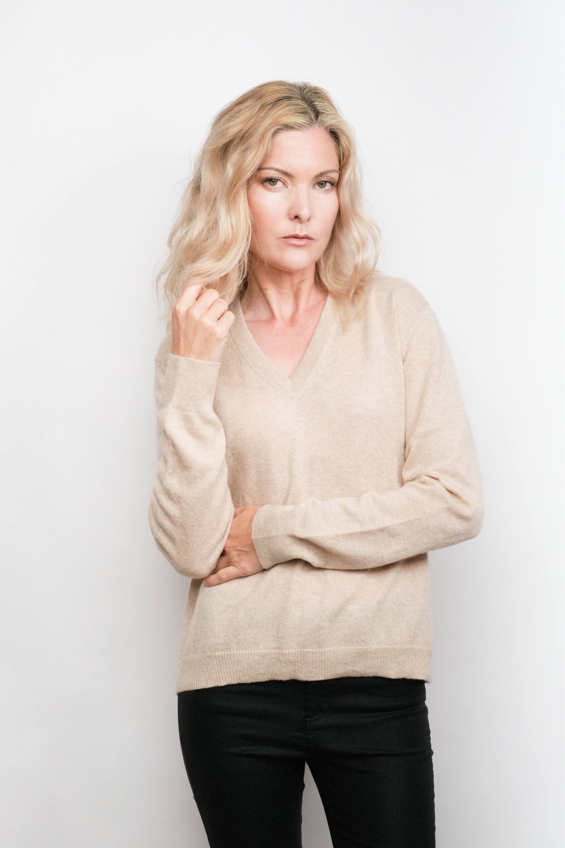 Model wearing beige cashmere V-neck sweater, studio view – Love Cashmere NZ