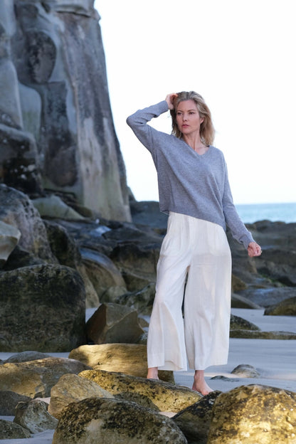 Woman in grey cashmere sweater standing on golden rocks – Love Cashmere NZ