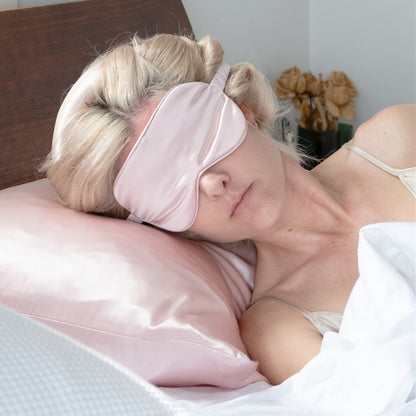 Woman sleeping on pink silk pillowcase wearing a silk eye mask – LS Silk NZ