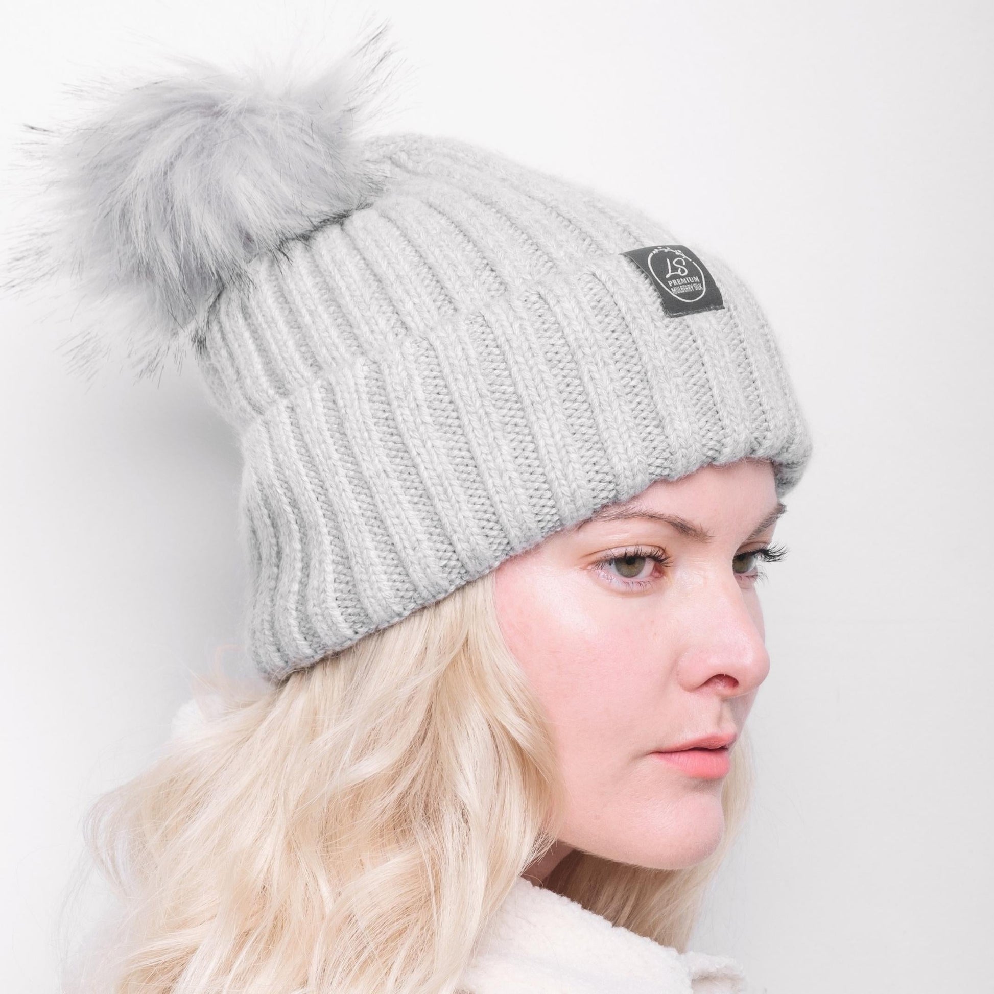 Side view of model wearing grey pom pom beanie – LS Silk NZ