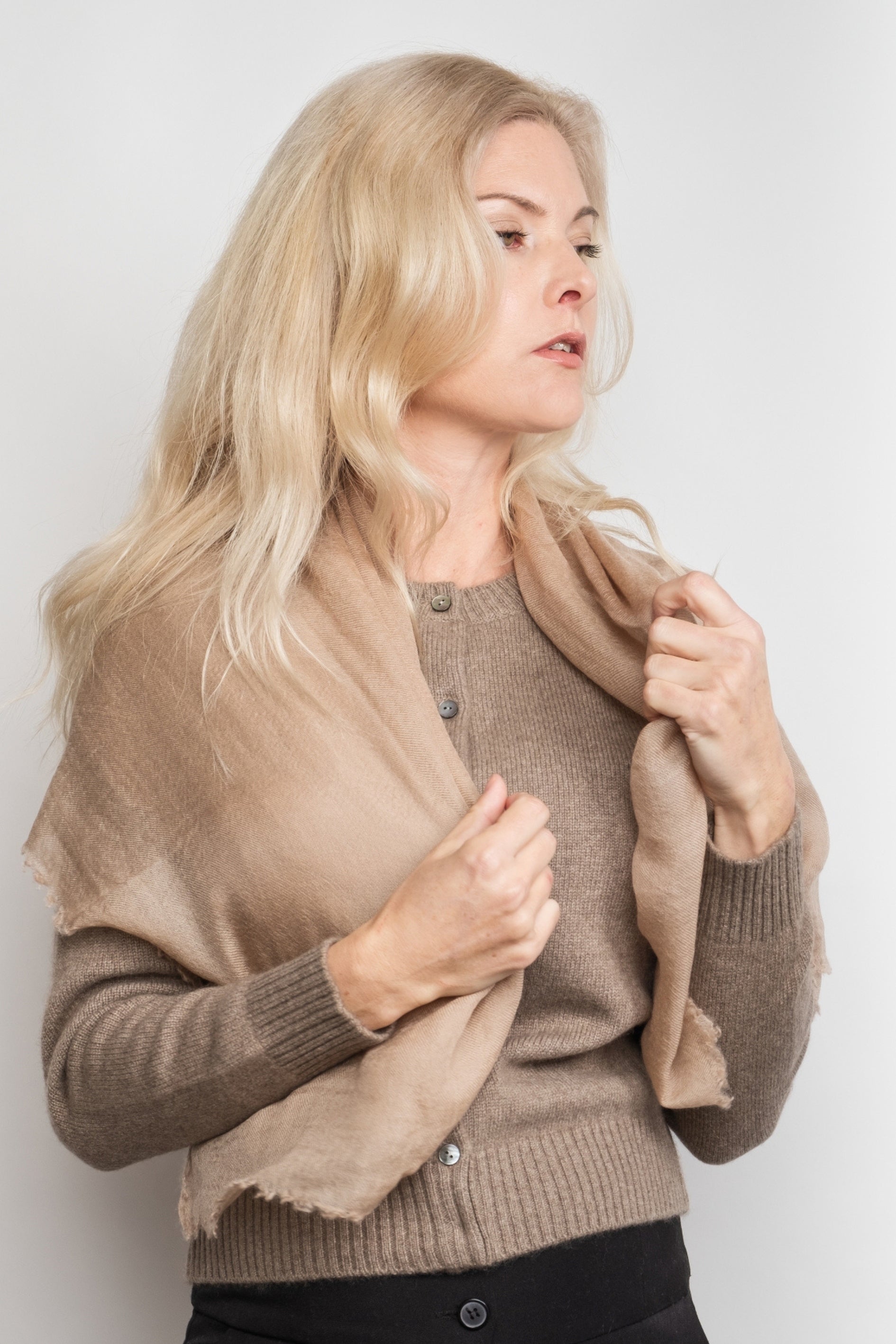 Woman draping sand cashmere scarf over her shoulders – Love Cashmere NZ