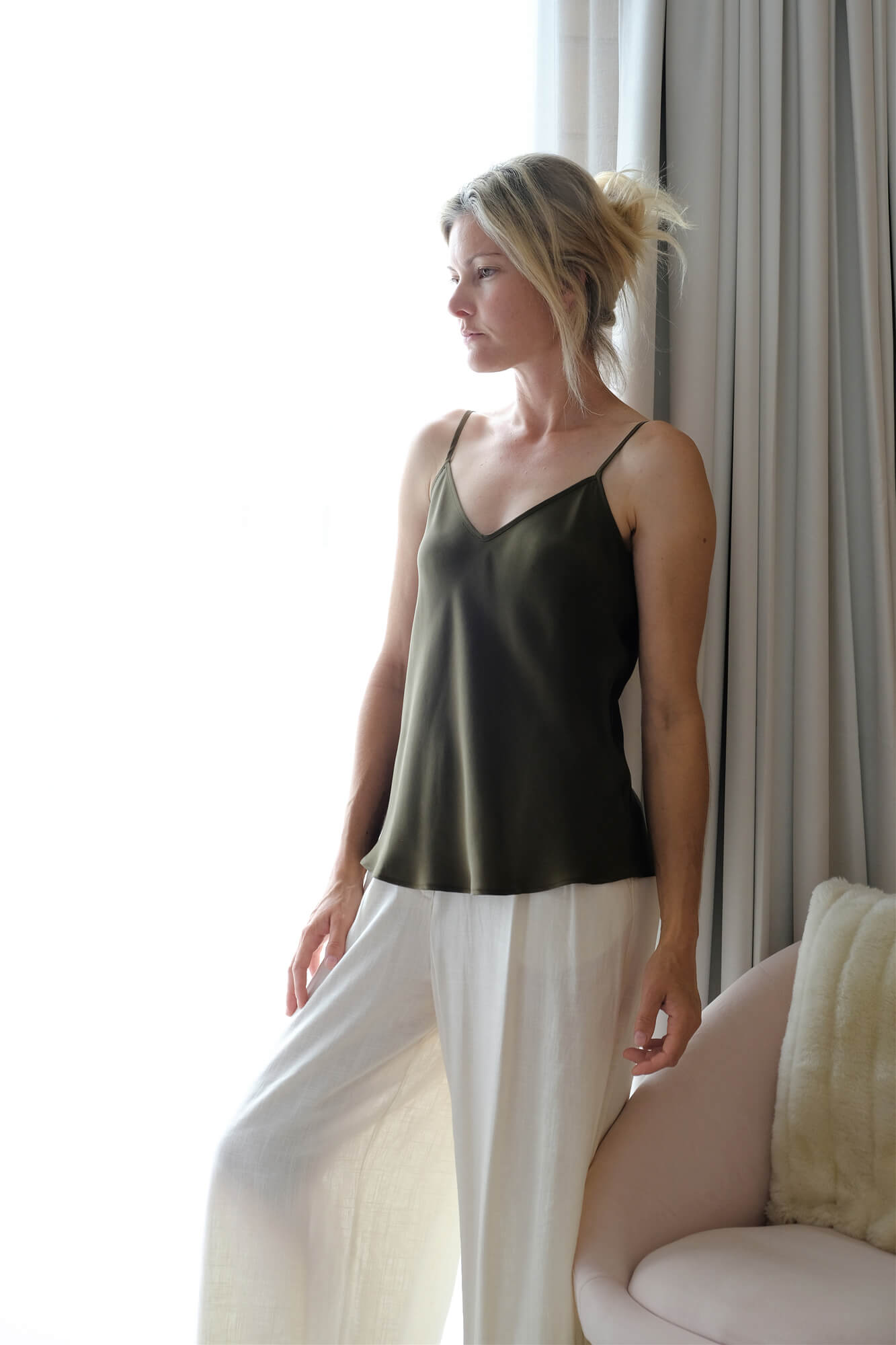 Woman in pine green mulberry silk camisole with white pants – LS Silk NZ