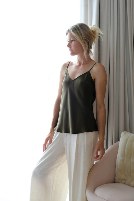 Woman in pine green mulberry silk camisole with white pants – LS Silk NZ