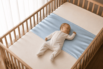 Baby asleep on their back on a sky blue silk cot sleeve in a wooden cot – LS Silk NZ