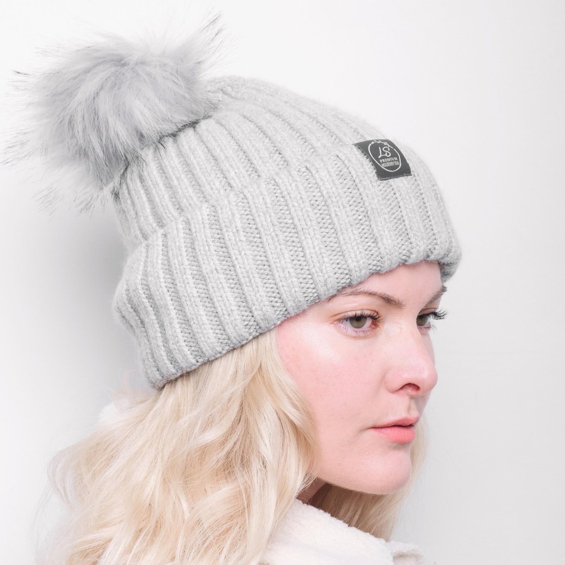 Side view of model wearing grey pom pom beanie – LS Silk NZ