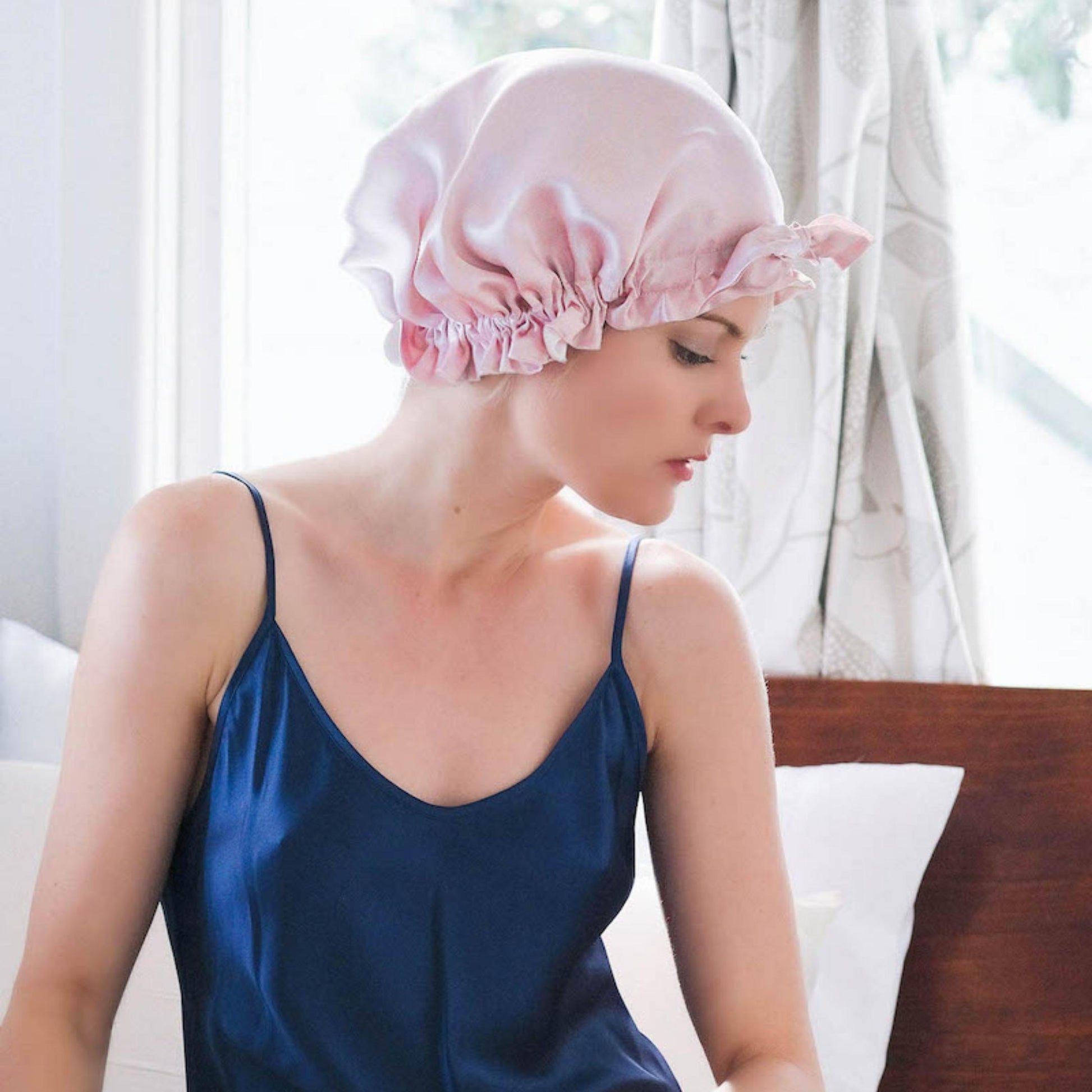 Woman in navy camisole wearing pink silk sleep bonnet – LS Silk NZ
