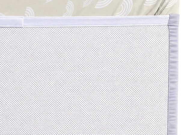 Close-up of the white mesh backing underneath the mattress, with the silk wrapping the side
